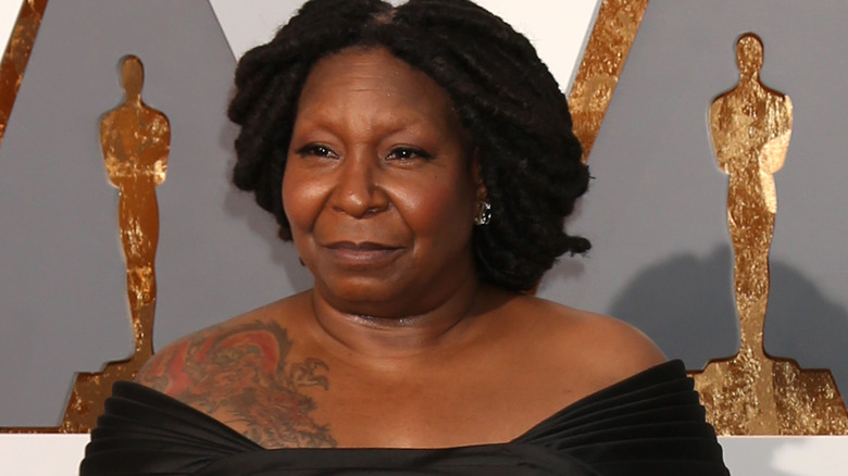 Whoopi Goldberg poses in a black dress