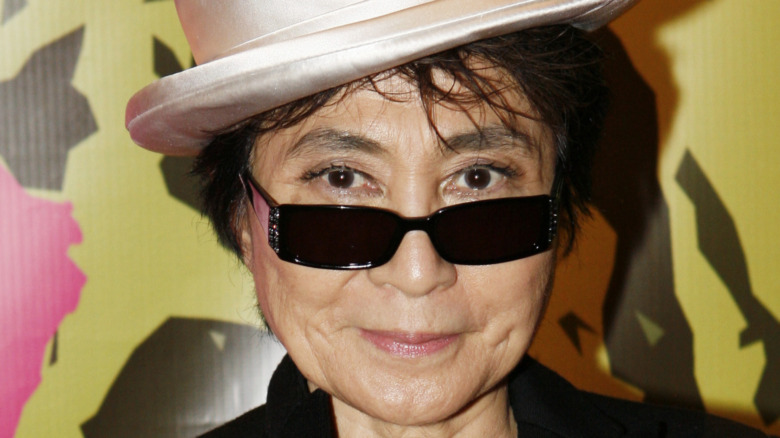 Yoko Ono poses in sunglasses and a hat