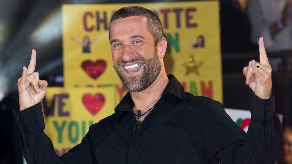 Dustin Diamond posing for a photo with hands raised