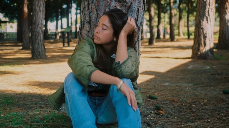 Lola Consuelos posing for cameras in front of tree