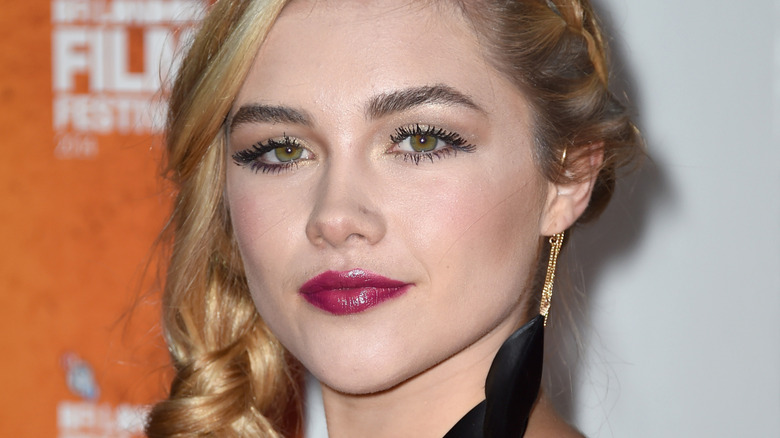 Florence Pugh with a large black earring, posing