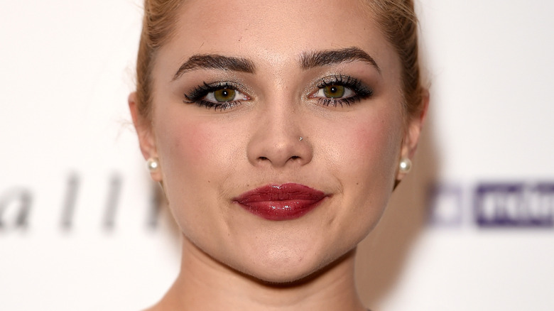 Florence Pugh with red lipstick, smiling