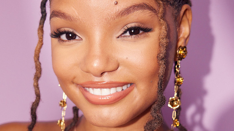 Halle Bailey smiling gold earrings