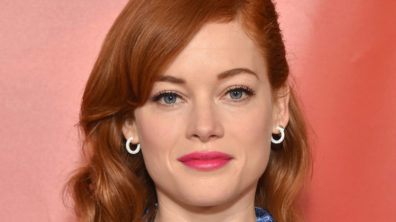 Jane Levy wearing pink lipstick, staring