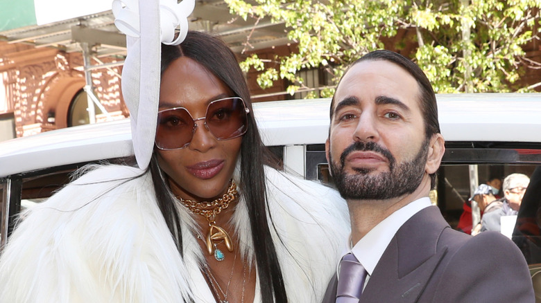 Naomi Campbell posing in white fascinator next to Marc Jacobs