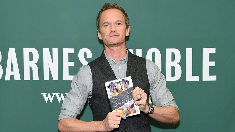 Neil Patrick Harris holds his book