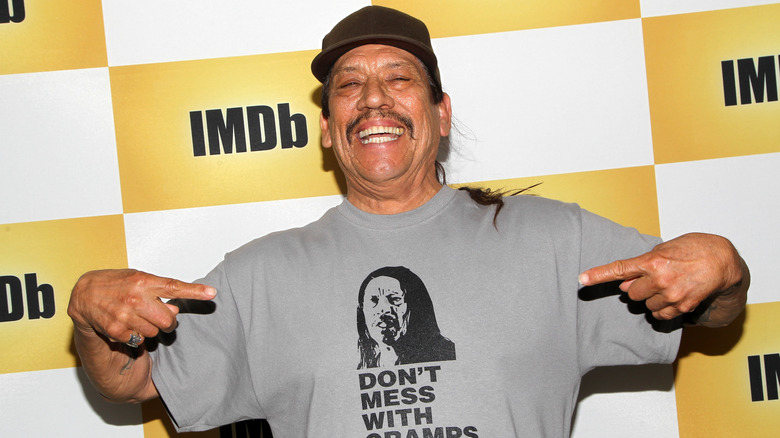 Danny Trejo smiling and pointing at t-shirt