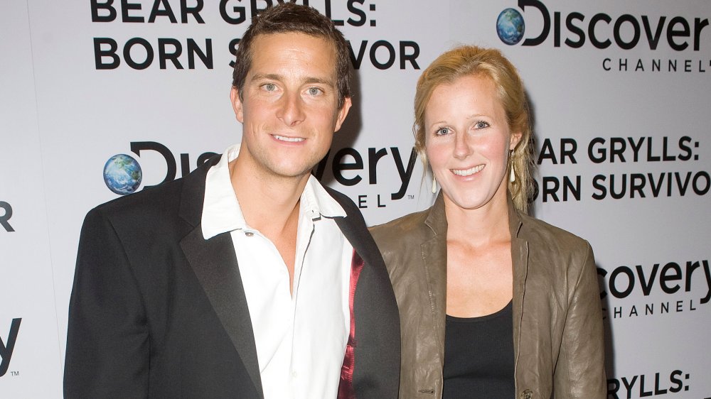 Bear Grylls and Shara Grylls in front of Discovery promo wall