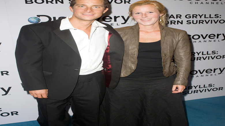 Bear Grylls and Shara Grylls in front of Discovery promo wall