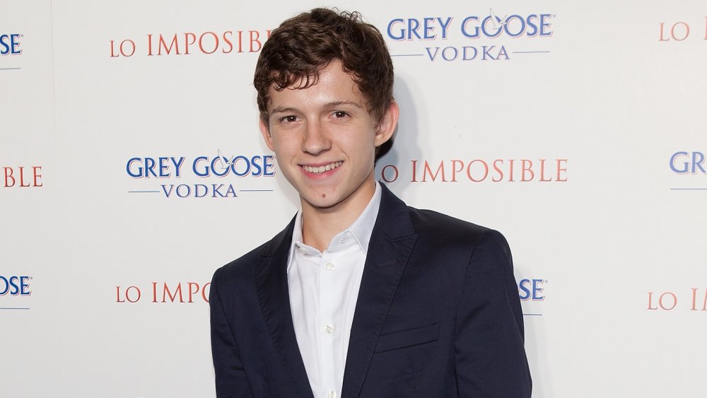A teenage Tom Holland smiling at The Impossible premiere