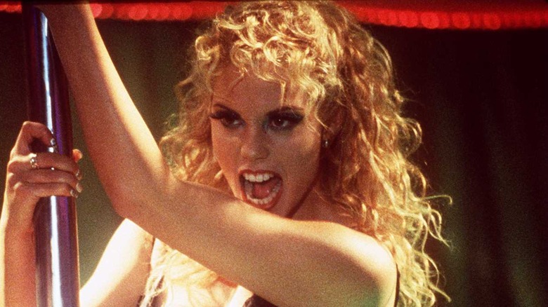 Elizabeth Berkley in holding a pole