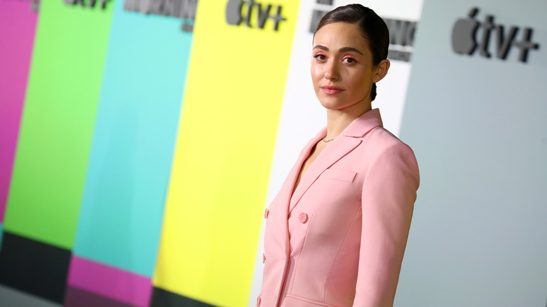 Emmy Rossum posing in front of a multicolored Apple TV+background in 2019