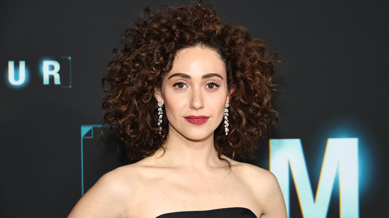 Emmy Rossum posing in front of a dark background