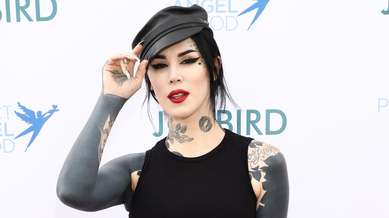 Kat Von D poses on a red carpet