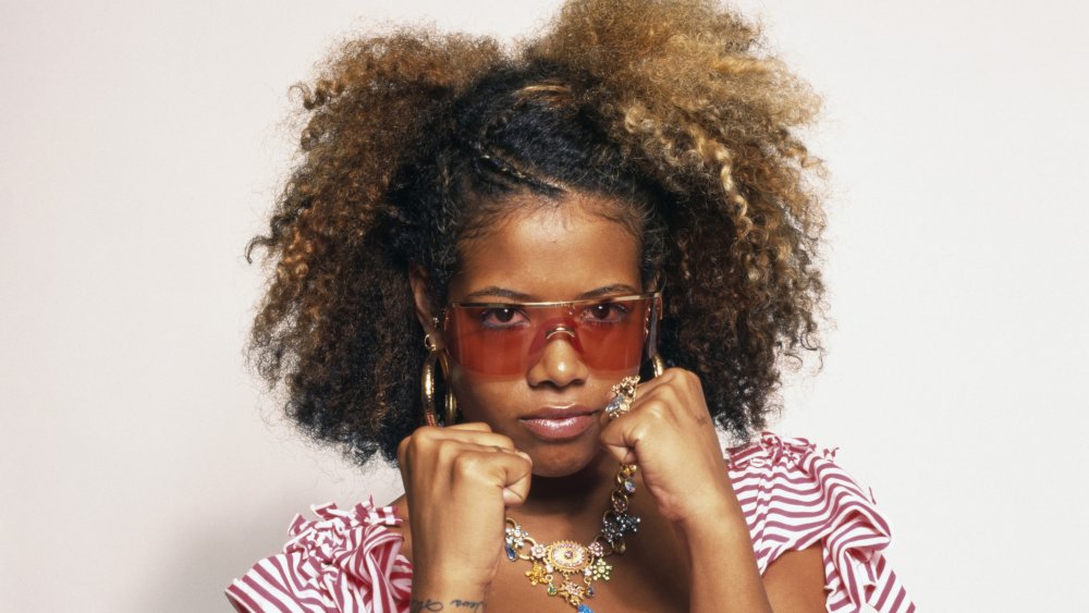 Kelis with fists up and red sunglasses