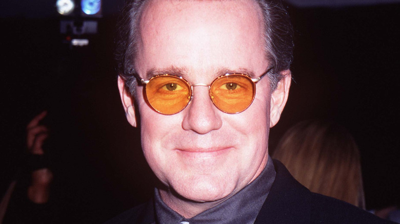 Phil Hartman posing in tinted glasses