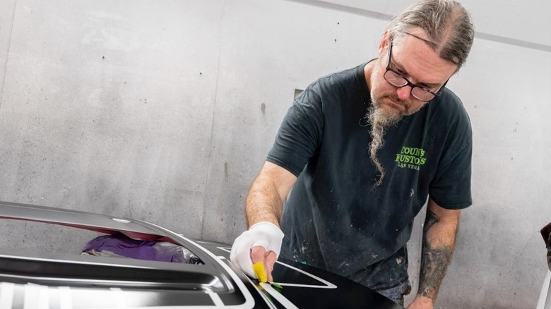 Ryan Evans working on car with glasses on