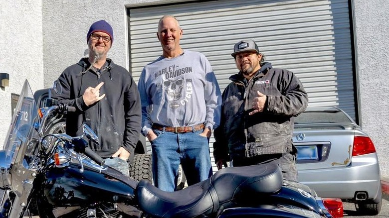 Ryan Evans posing with a motorcycle and customer
