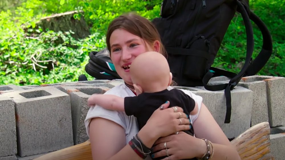 Snowbird Brown holding a baby