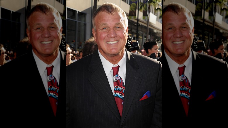 Reb Brown smiling on the red carpet wearing a Captain America tie at the premiere for "Captain America: The First Avenger."