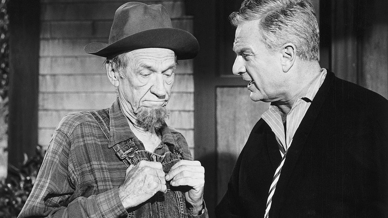 A black and white photo of Hank Patterson in costume interacting with Eddie Albert on the set of 'Green Acres'