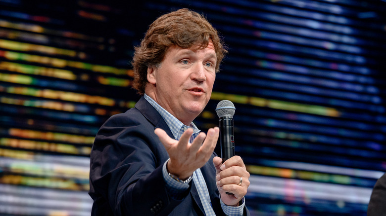 Tucker Carlson speaking into a microphoe