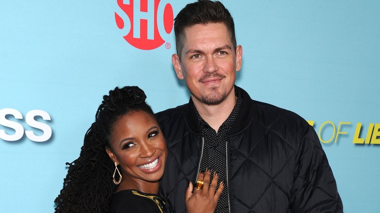 Shanola Hampton smiles while leaning on a gleeful Steve Howey.