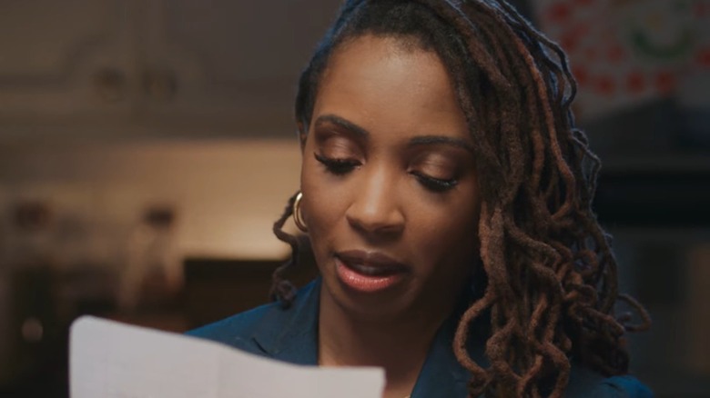 Wearing her dreadlocked hair down, Shanola Hampton reads a letter.