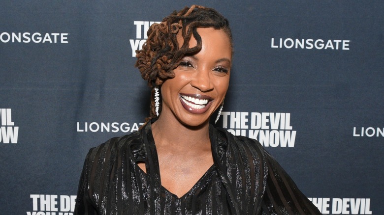 Dressed in a black outfit, Shanola Hampton sports a broad smile.