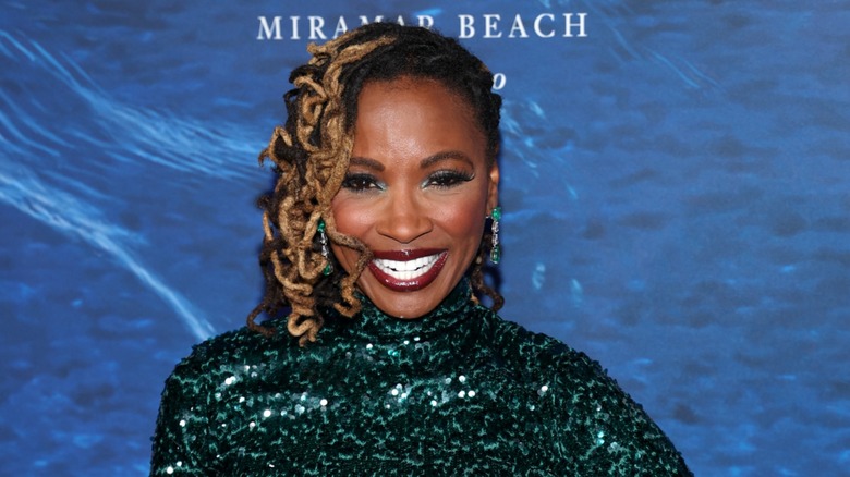 Shanola Hampton is all smiles in a shimmery green outfit and matching makeup.