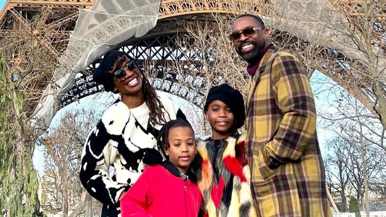 Shanola Hampton and her family display beaming smiles in front of the Eiffel Tower.