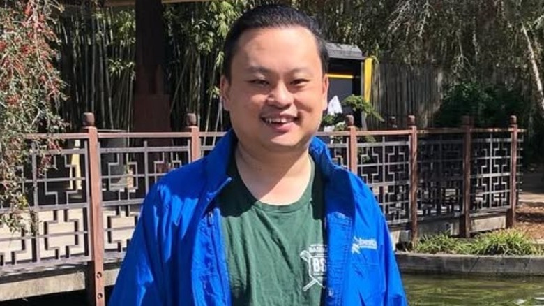 William Hung smiling and posing in an outdoor garden