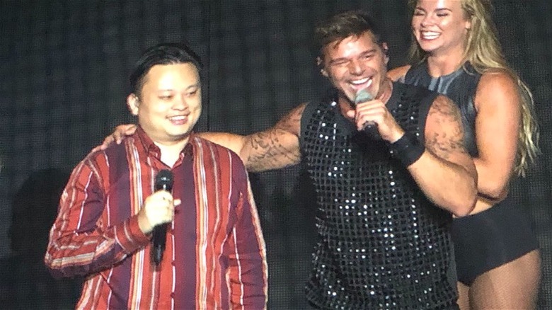 Ricky Martin putting his arm around William Hung's shoulder, with both holding microphones and smiling
