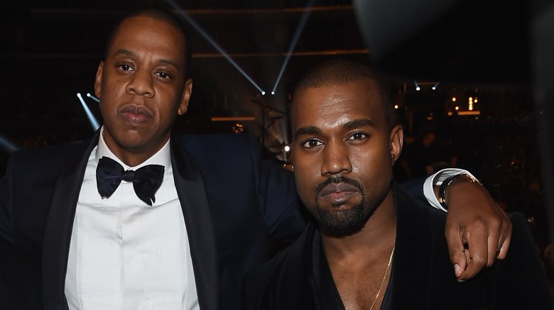 Jay-Z in tux with arm around Kanye