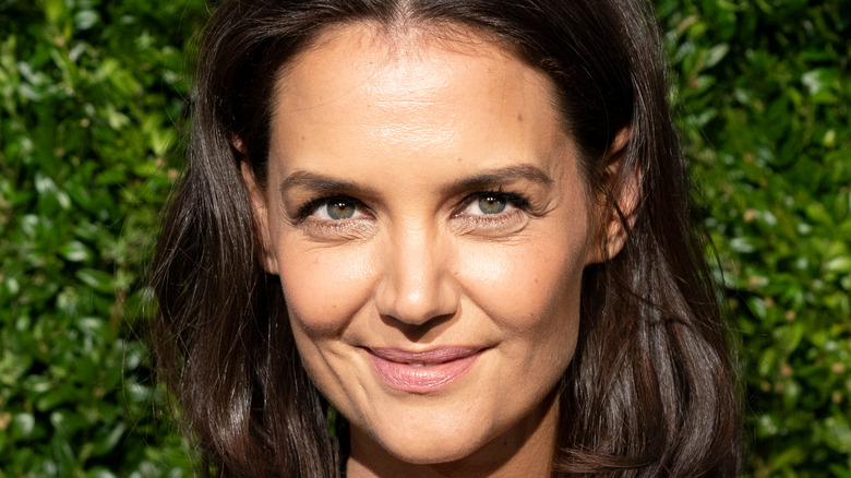 Katie Holmes in front of greenery