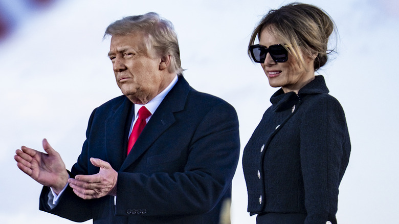 Donald Trump clapping and Melania Trump smiling