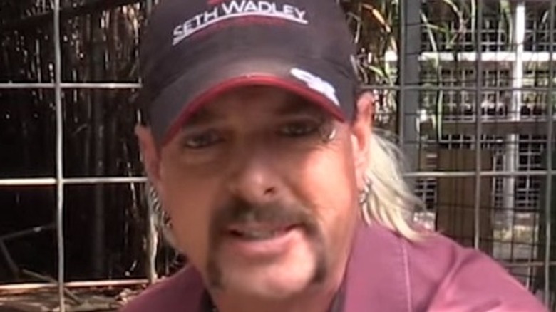 Joe Exotic smiling in front of cages