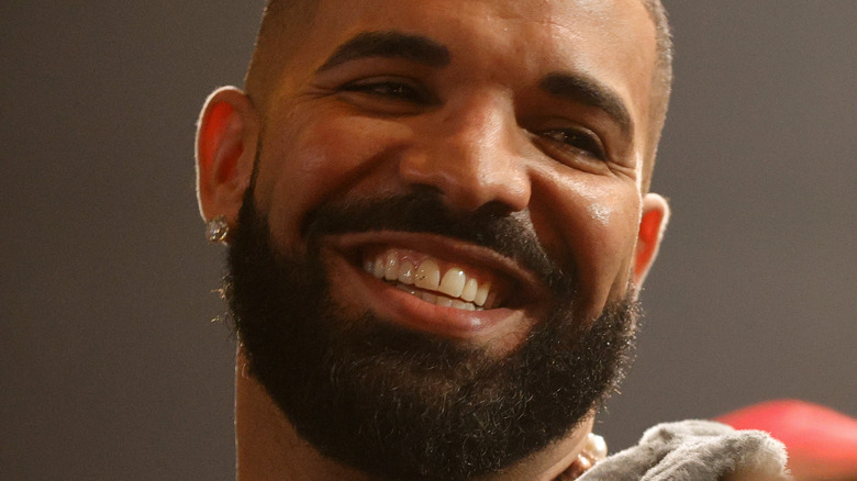 Drake smiling big bushy beard diamond earrings