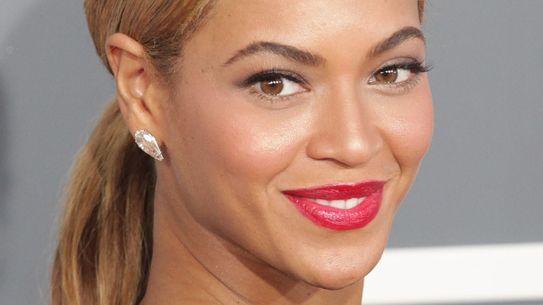 Beyoncé smiling red lip ponytail