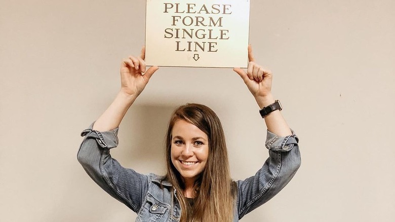 Jana Duggar holding sign over head