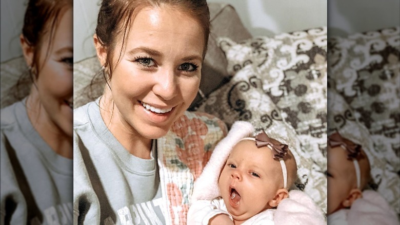 Jana Duggar holding a yawning baby
