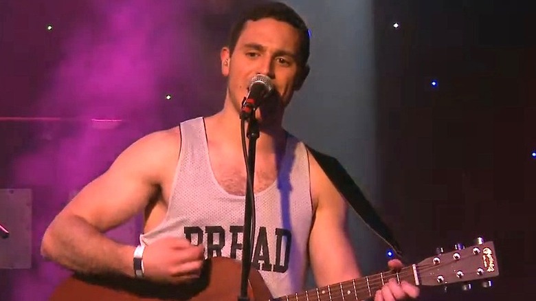 John Moustis singing and playing guitar
