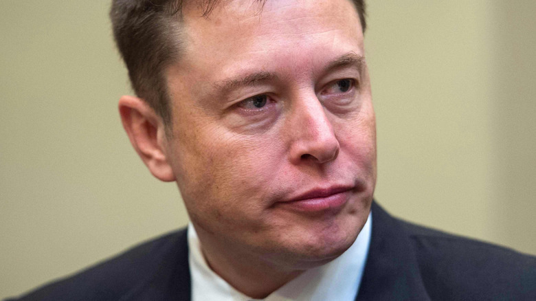 Elon Musk at a conference looking to the side with a serious expression