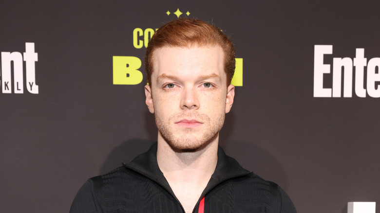 Cameron Monaghan staring ahead in black zip-up shirt