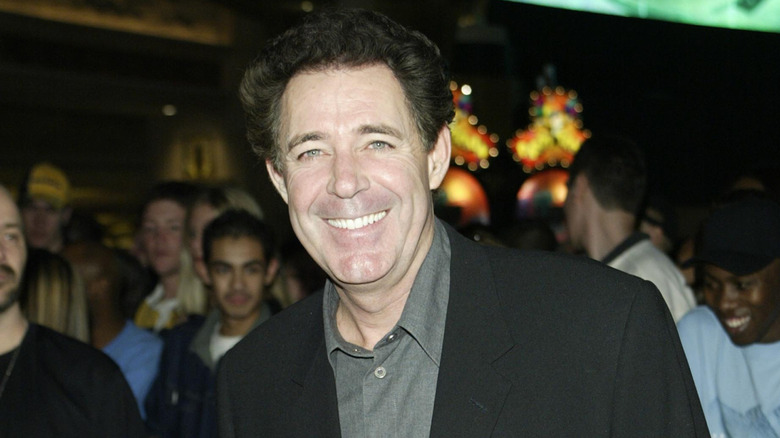 Barry Williams smiles in a gray shirt and black jacket in 2002.
