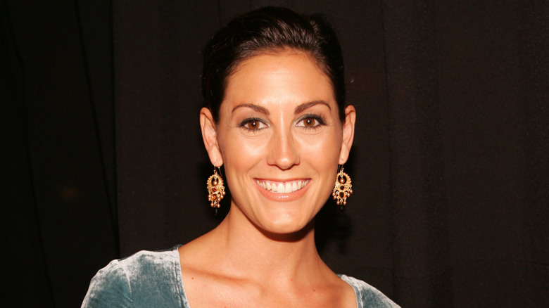 Trish Schneider in front of a dark background while attending premiere for The Scorned