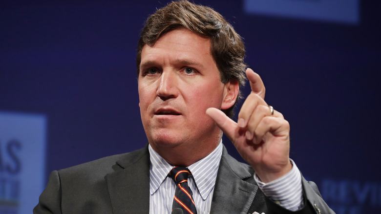 Tucker Carlson with his fingers up