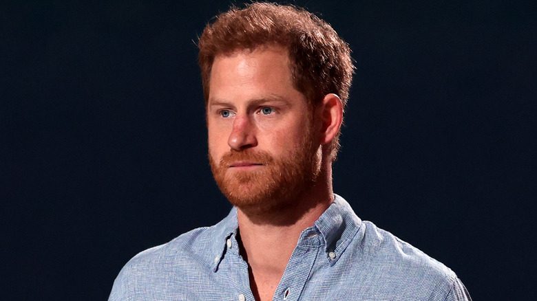 Prince Harry looks solemn on stage