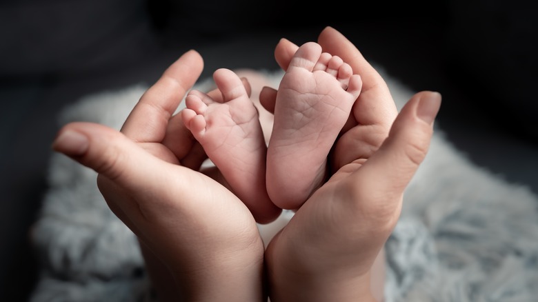 mother holding baby feet