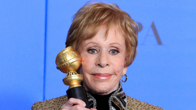 Carol Burnett smiling and holding award at the Golden Globes